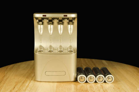 battery charger and four batteries waiting to be chargedの写真素材