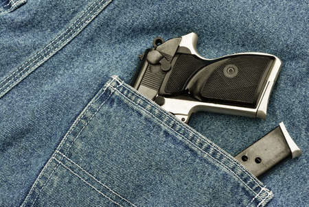 small pistol and magazine in denim pants pocketの写真素材