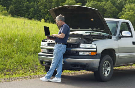 man searching for help on the internet after vehicle breaks down