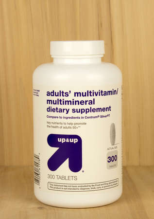 RIVER FALLS,WISCONSIN-MAY 02,2017: A bottle of Up and Up brand adult vitamins with a wood background.のeditorial素材