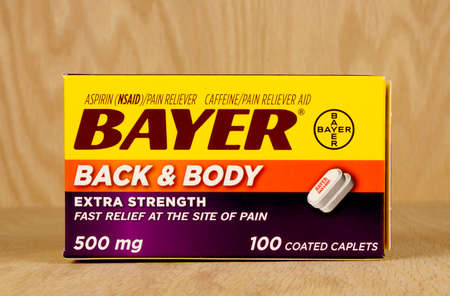 RIVER FALLS,WISCONSIN-JUNE 10,2017: A box of Bayer brand back and body pain relief caplets with a wood background.のeditorial素材