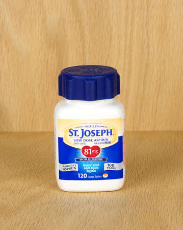 RIVER FALLS,WISCONSIN-JULY 21,2017: A bottle of St. Joseph brand low dose aspirin with a wood backgound.のeditorial素材