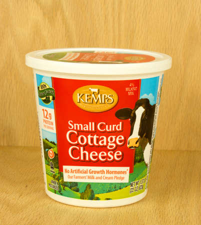 RIVER FALLS,WISCONSIN-AUGUST 29,2017: A container of Kemp's brand cottage cheese with a wood background.のeditorial素材
