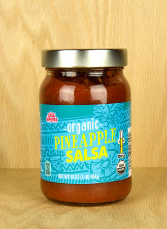 RIVER FALLS,WISCONSIN-SEPTEMBER 16,2017: A jar of Casa Mamita brand pineapple salsa with a wood background.のeditorial素材