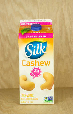 RIVER FALLS,WISCONSIN-SEPTEMBER 25,2017: A carton of Silk brand cashew milk with a wood background.のeditorial素材