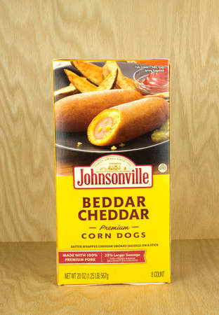 RIVER FALLS,WISCONSIN-OCTOBER 21,2017: A box of Johnsonville brand cheddar flavored corn dogs with a wood background.のeditorial素材