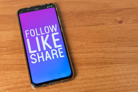Follow Like Share - Phone on tableの写真素材