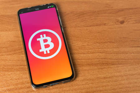 Phone with Bitcoin on tableの写真素材