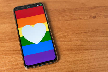 Phone with LGBT flag and heart on tableの写真素材