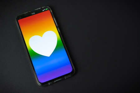 Phone with LGBT flag and heart on black backgroundの写真素材