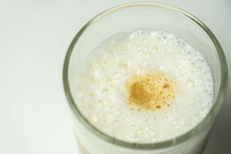 Glass of latte coffee on light backgroundの写真素材
