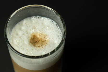 Glass of latte coffee on black backgroundの写真素材