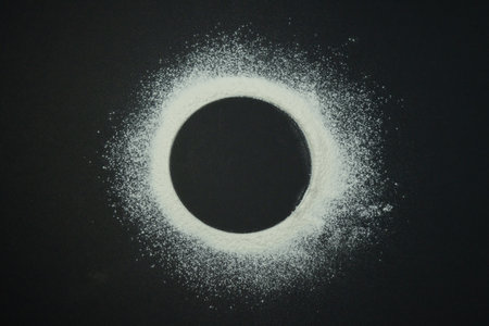 Flour in the form of a circle on a black backgroundの写真素材