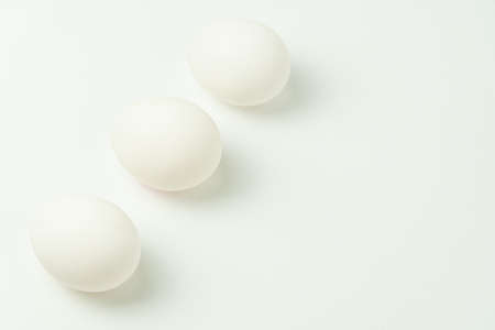 Three chicken eggs on a solid backgroundの写真素材