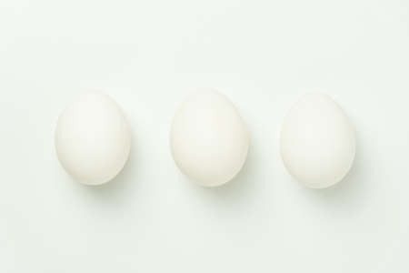 Three chicken eggs on a solid background
