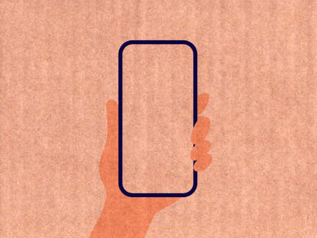 Hand holding a phone on a cardboard textureの写真素材
