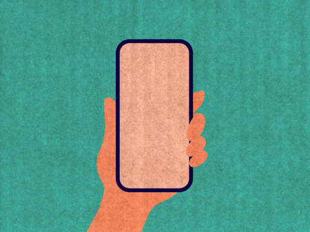 Hand holding a phone on a green cardboard textureの写真素材