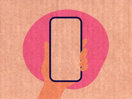Hand holding a phone on a pink cardboard textureの写真素材