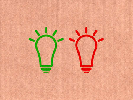 Green and red light bulb icon on cardboard textureの写真素材