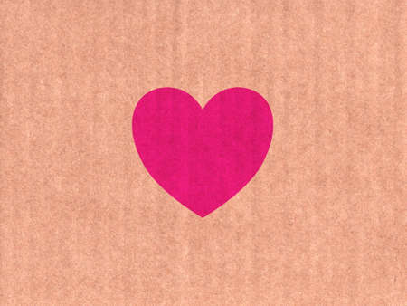 Pink heart icon on cardboard textureの写真素材