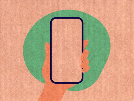 Hand holding a phone on a green cardboard textureの写真素材