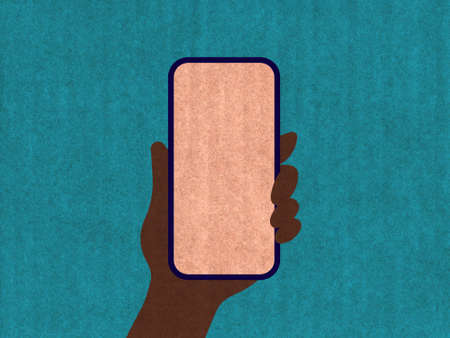 Hand holding a phone on a blue cardboard textureの写真素材