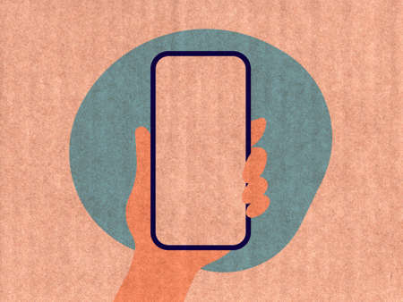 Hand holding a phone on a blue cardboard textureの写真素材