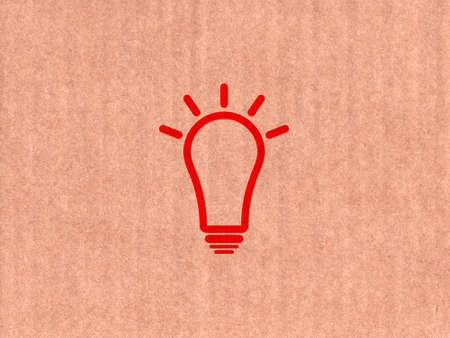 Red light bulb icon on cardboard textureの写真素材