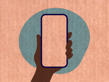 Hand holding a phone on a blue cardboard textureの写真素材