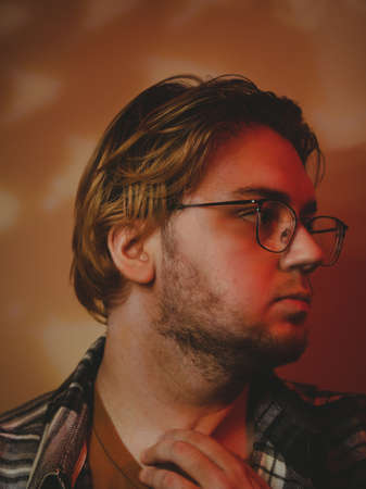 Portrait of a young man with colored lightの写真素材