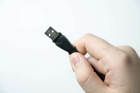 Hand holding usb cable on white backgroundの写真素材