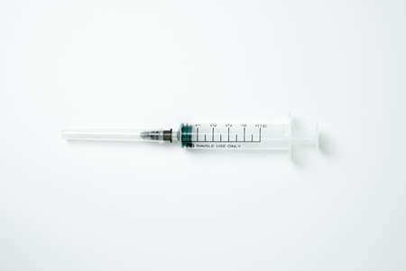 Medical syringe and needle on a light backgroundの写真素材