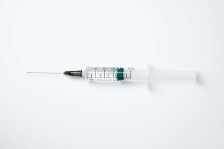 Medical syringe and needle with medicament on a light backgroundの写真素材