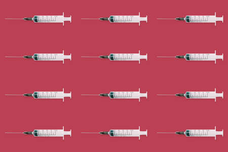 Seamless pattern with medical syringe and needle on red backgroundの写真素材