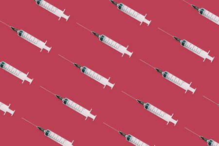 Seamless pattern with medical syringe and needle on red backgroundの写真素材