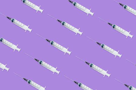 Seamless pattern with medical syringe and needle on purple backgroundの写真素材