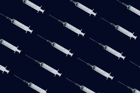 Seamless pattern with medical syringe and needle on dark backgroundの写真素材