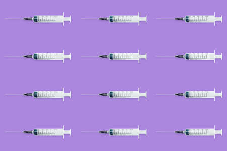 Seamless pattern with medical syringe and needle on purple backgroundの写真素材