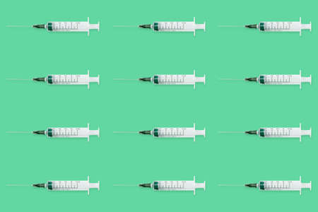 Seamless pattern with medical syringe and needle on green backgroundの写真素材