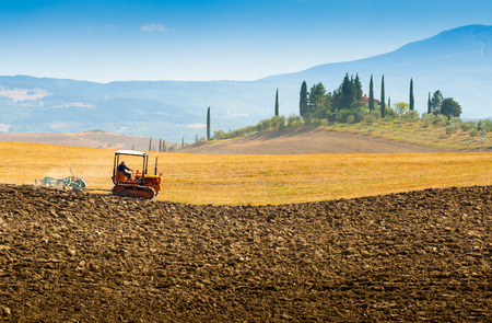 ploughing on hills in Crete Senesi near Asciano, Tuscany, Italyの写真素材