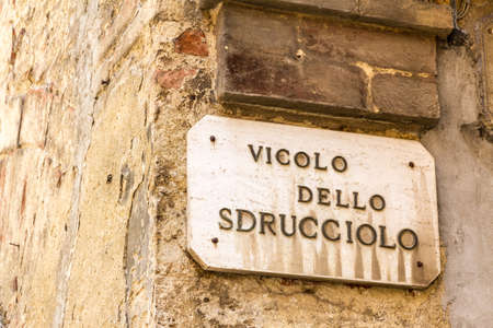\"Vicolo dello Sdrucciolo\" means \"slippery alley\" in Italian. Road sign in Montepulciano, Tuscanyの写真素材