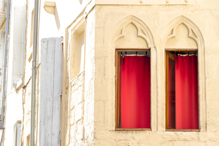 Montpellier, France. Two windows with decorations and red curtains in the old townの写真素材