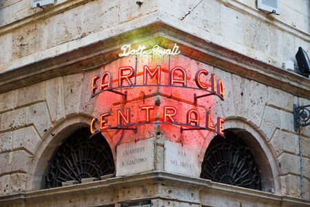 Ascoli Piceno, Italy - June 27, 2019: glowing neon sign in the old town readings: 'Doctor Rosati Central pharmacy" at sunsetのeditorial素材