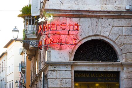 Ascoli Piceno, Italy - June 27, 2019: glowing neon sign in the old town readings: 'Doctor Rosati Central pharmacy" at sunsetのeditorial素材