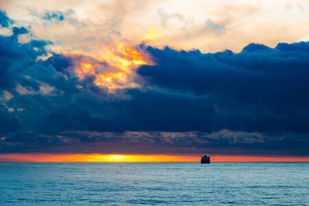Sea sunset landscape with cloud  sun reflection and ship on the horizonの写真素材