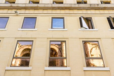 The arena of Nimes, France, reflected on some reflective modern windows nearbyの写真素材
