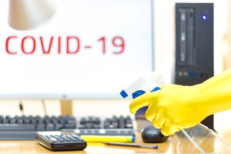 Disinfecting of an office with spray and glove to prevent COVID-19 diseaseの写真素材