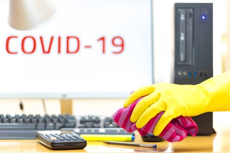 Disinfecting of an office with spray and glove to prevent COVID-19 diseaseの写真素材