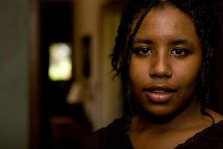 Troubled African American teenage girl at home.の写真素材
