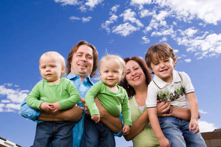 Happy family with twins outside in the sun.の写真素材